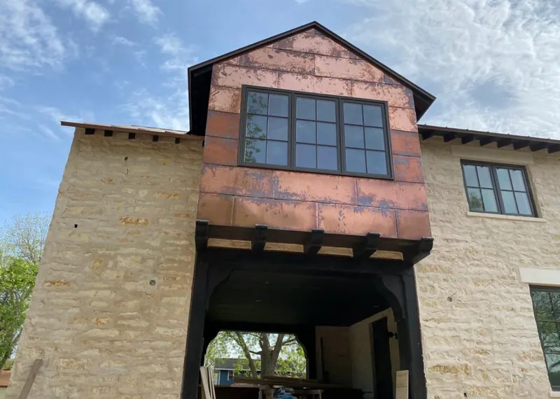 Copper metal panel facade on a stone building for Skylight Installation in El Campo